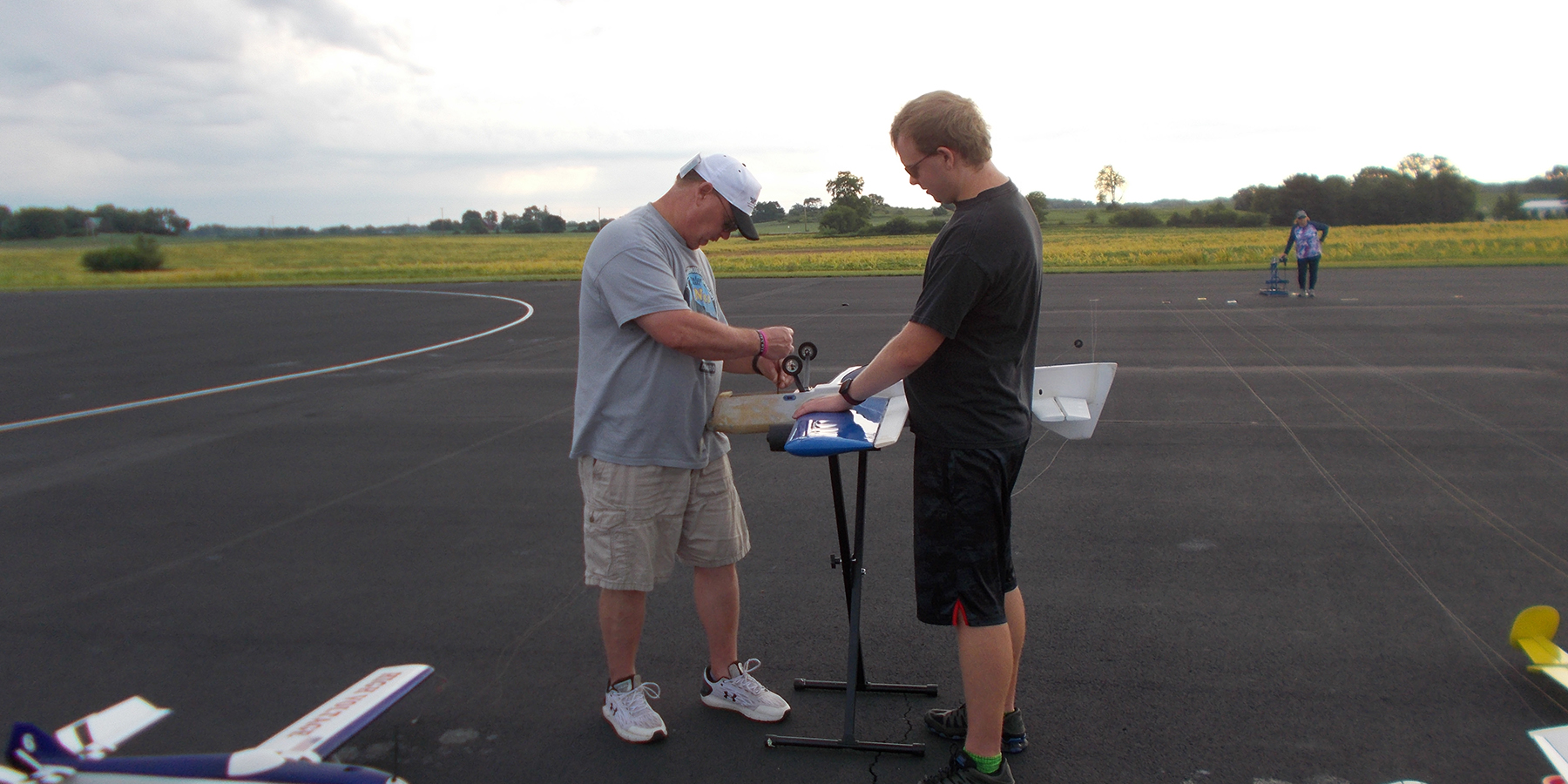 9.	James Mills works on Ben’s (his son) airplane in the pits.