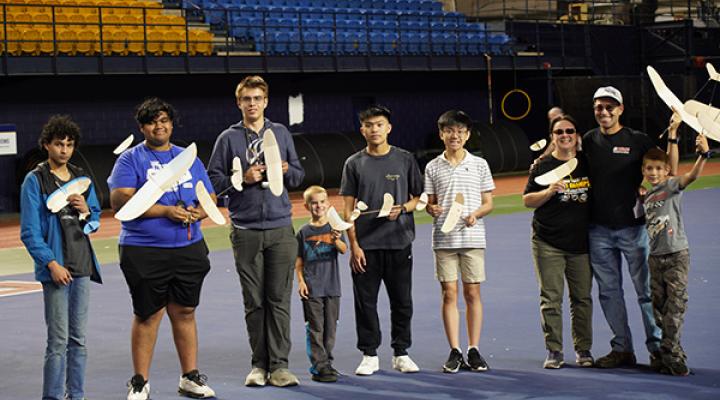 Group with model airplanes in a stadium setting.