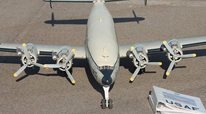 Model propeller plane on a runway with USAF documents nearby.
