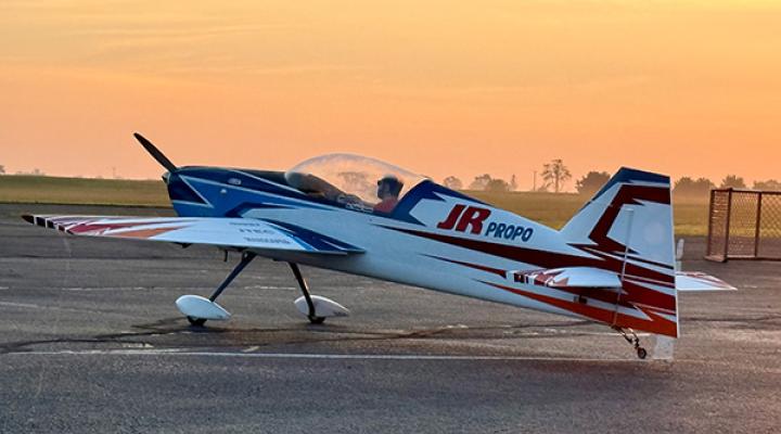 Small propeller plane on tarmac at sunset.